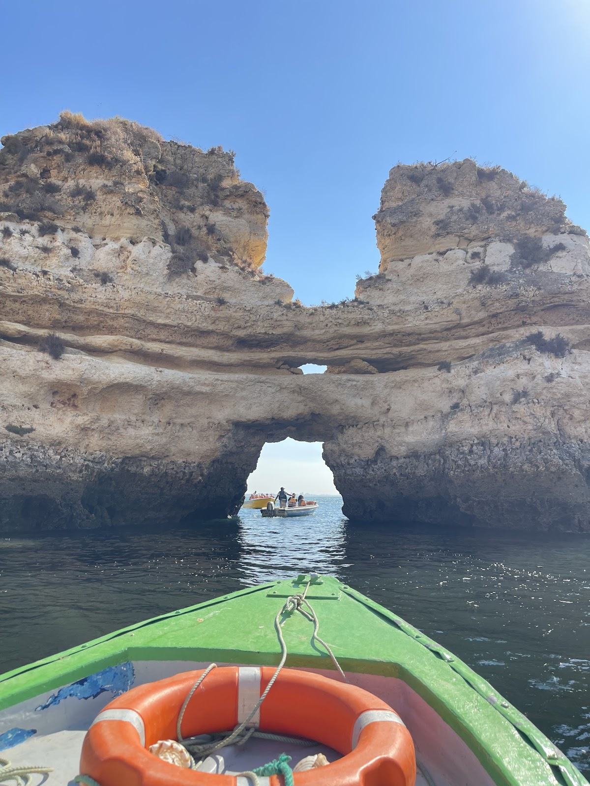 Barco pequeno a entrar numa gruta da Ponta da Piedade